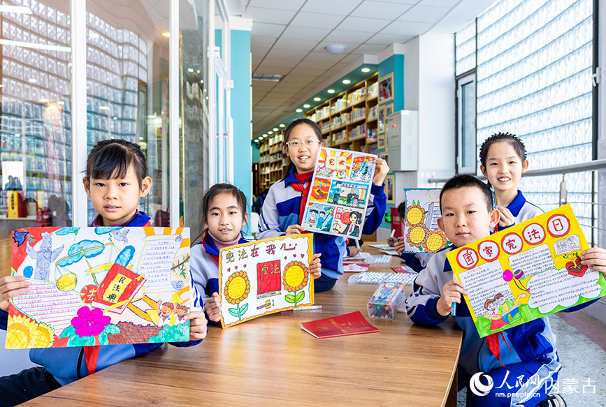 12月4日，呼和浩特市玉泉区通顺街小学学生在展示绘制的以国家宪法日为主题的手抄报。丁根厚摄