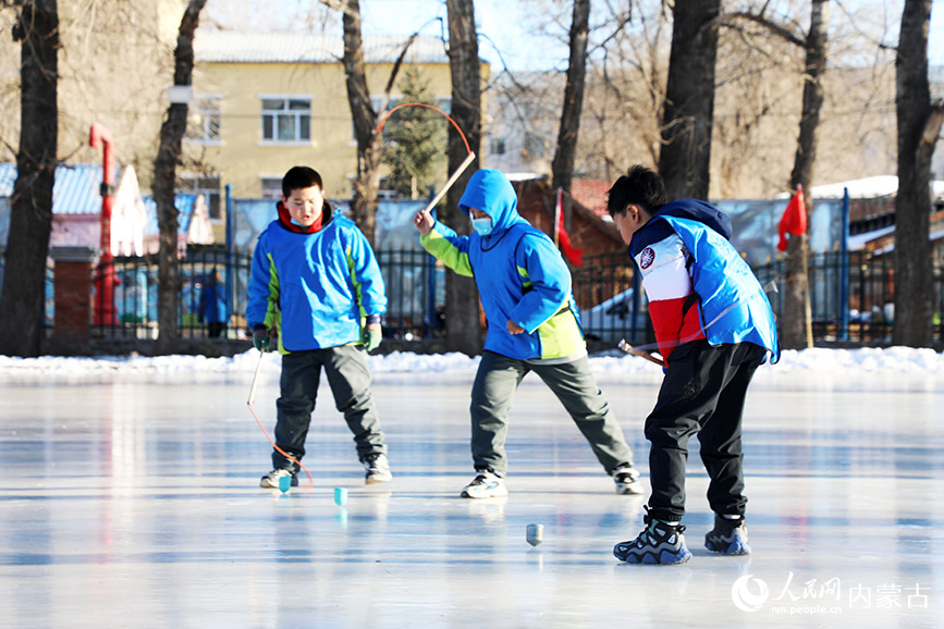 12月6日，内蒙古自治区呼伦贝尔市扎兰屯市实验小学滑冰场，同学们在“冰雪课堂”进行打冰嘎比赛。韩冷摄