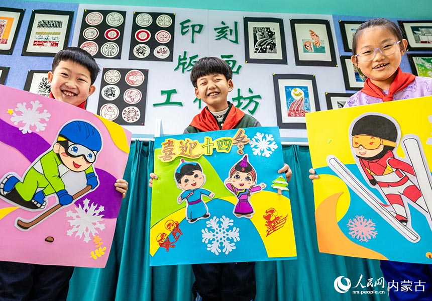 呼和浩特市玉泉区小召小学学生在展示绘制的“十四冬”吉祥物“安达”和“赛努”，运动形象手工作品。丁根厚摄