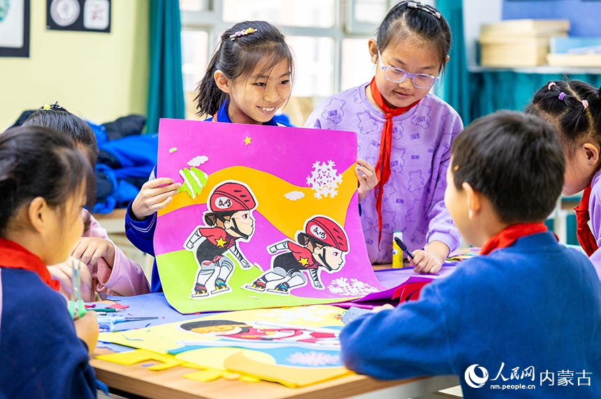 呼和浩特市玉泉區小召小學學生在展示繪制的冰雪運動形象手工作品。丁根厚攝