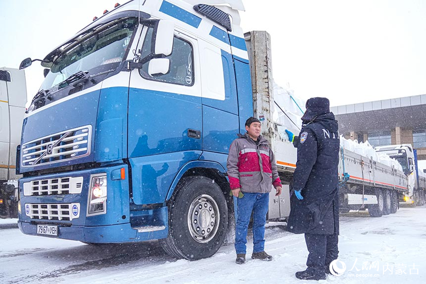 二连出入境边防检查站移民管理警察顶风冒雪查验通关车辆。杨金烨摄