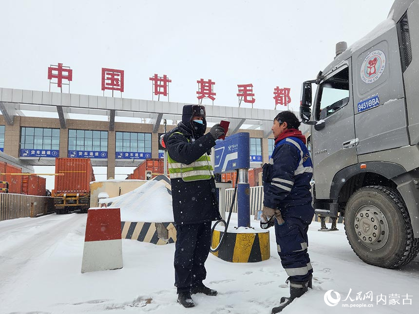 甘其毛都边检站移民管理警察核对司机出入境证件。贺猛摄
