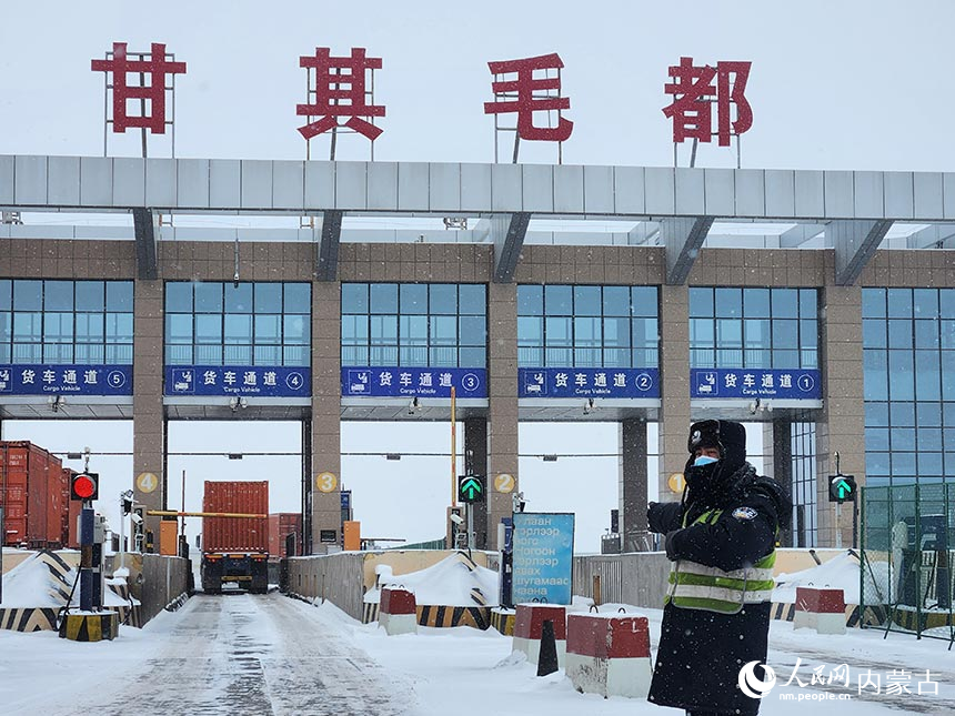 甘其毛都边检站移民管理警察指引车辆顺畅通关。贺猛摄
