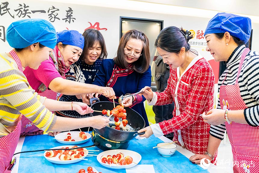 呼和浩特市玉泉区兴隆巷街道清泉街社区志愿者和居民在制作冰糖葫芦。丁根厚摄