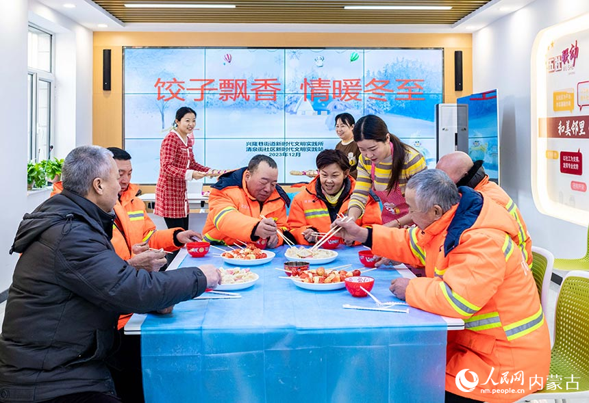 环卫工人在呼和浩特市玉泉区兴隆巷街道清泉街社区品尝冬至饺子。丁根厚摄
