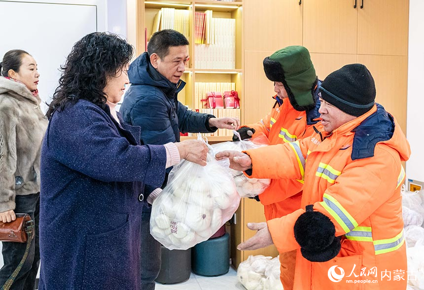 呼和浩特市平泽食品有限责任公司的工作人员为环卫工人送上爱心包子等食品。丁根厚摄