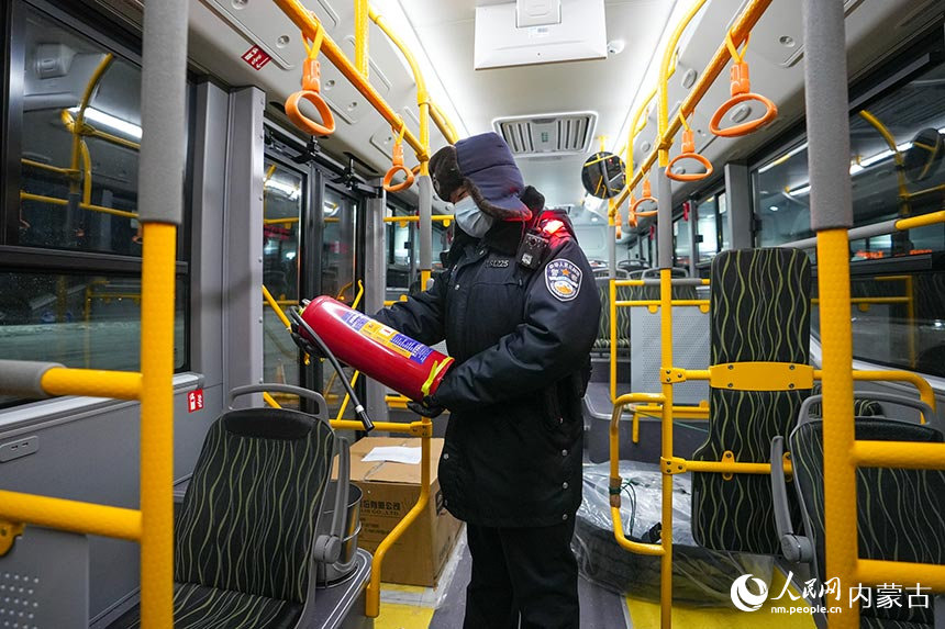 二连出入境边防检查站移民管理警察对出境公交车进行车体检查。杨金烨摄