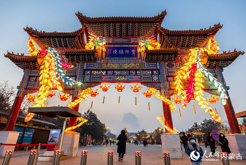 游人在呼和浩特市玉泉区塞上老街旅游休闲街区观赏“龙凤呈祥”灯组。丁根厚摄