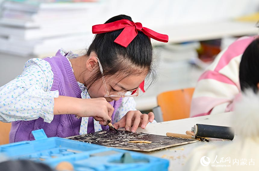 鄂托克前旗第二小學版畫社團學生在體驗版畫制作技藝。王正攝