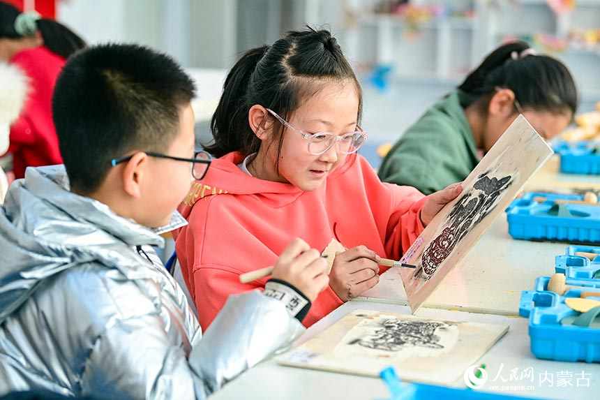 鄂托克前旗第二小學版畫社團學生在交流版畫制作技藝。王正攝