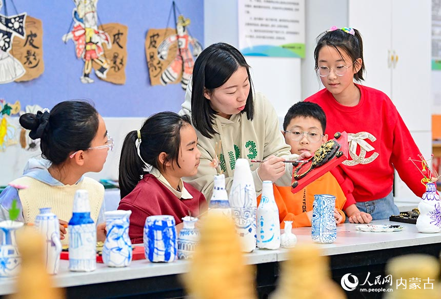 鄂托克前旗第二小學泥塑社團教師指導學生學習泥塑制作技藝。王正攝