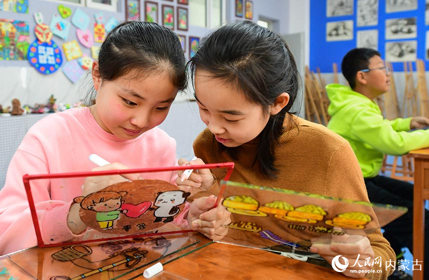 鄂托克前旗第二小学玻璃画社团学生在绘制玻璃画。王正摄