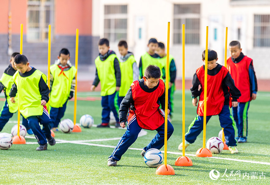 2024年1月8日，呼和浩特市玉泉區南茶坊小學的小球員們在足球場進行帶球訓練。丁根厚攝