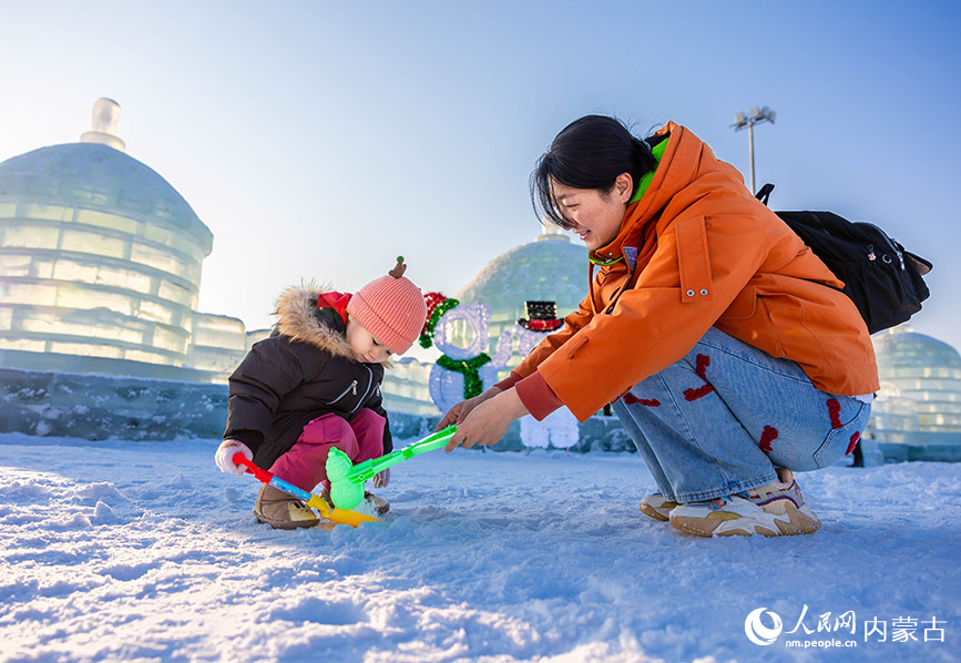 2024年1月12日，家長陪伴孩子在第三屆呼和浩特歡樂冰雪節活動現場玩雪。丁根厚攝