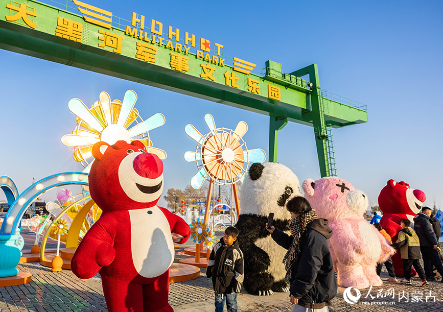 2024年1月12日，游客在第三屆呼和浩特歡樂冰雪節活動現場與卡通人偶互動。丁根厚攝