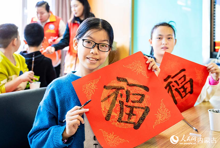 孩子们在“品传统年韵 迎龙年新春”主题活动现场展示自己书写的中国“福”。丁根厚摄