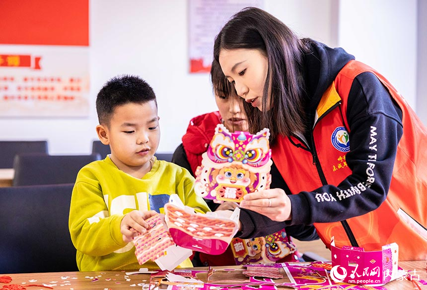 志願者在“品傳統年韻 迎龍年新春”主題活動現場教孩子們拼裝龍年花燈。丁根厚攝