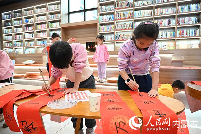 康巴什區青春山街道神華康城社區“青苗學社”內，小朋友正在寫春聯。人民網記者 劉藝琳攝