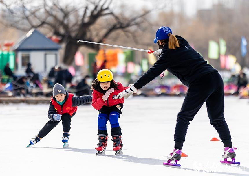 内蒙古呼和浩特市青城公园公益冰场，小朋友在专业老师的指导下学习滑冰。丁根厚摄