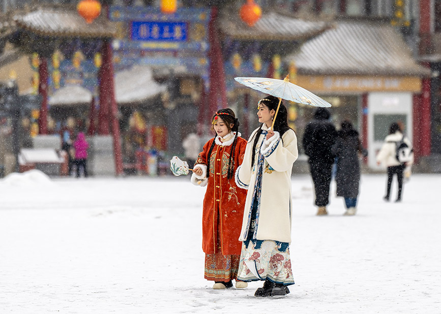2月20日，人们在呼和浩特市玉泉区塞上老街旅游休闲街区冒雪游玩。丁根厚摄