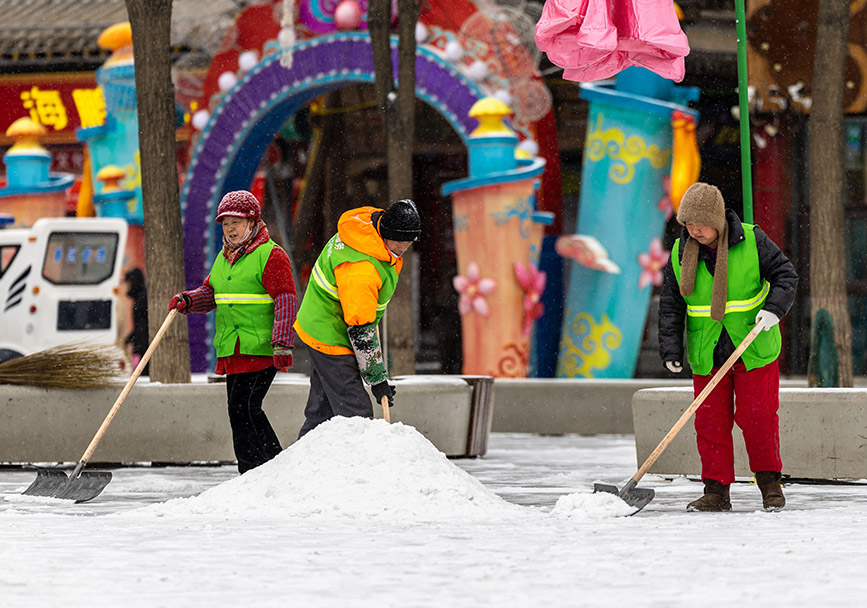 2月20日，环卫工人在呼和浩特市玉泉区塞上老街旅游休闲街区清除积雪。丁根厚摄