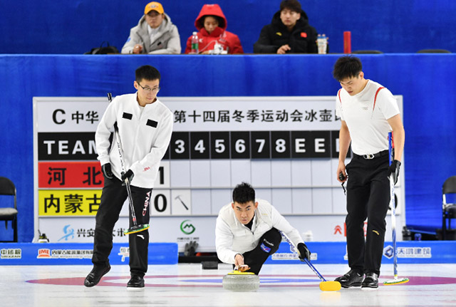 2月21日，内蒙古队选手杨洋（中）在比赛中掷壶。胡建生摄