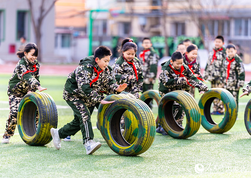 2月26日，呼和浩特市玉泉区五塔寺东街小学学生在进行滚轮胎趣味游戏。丁根厚摄