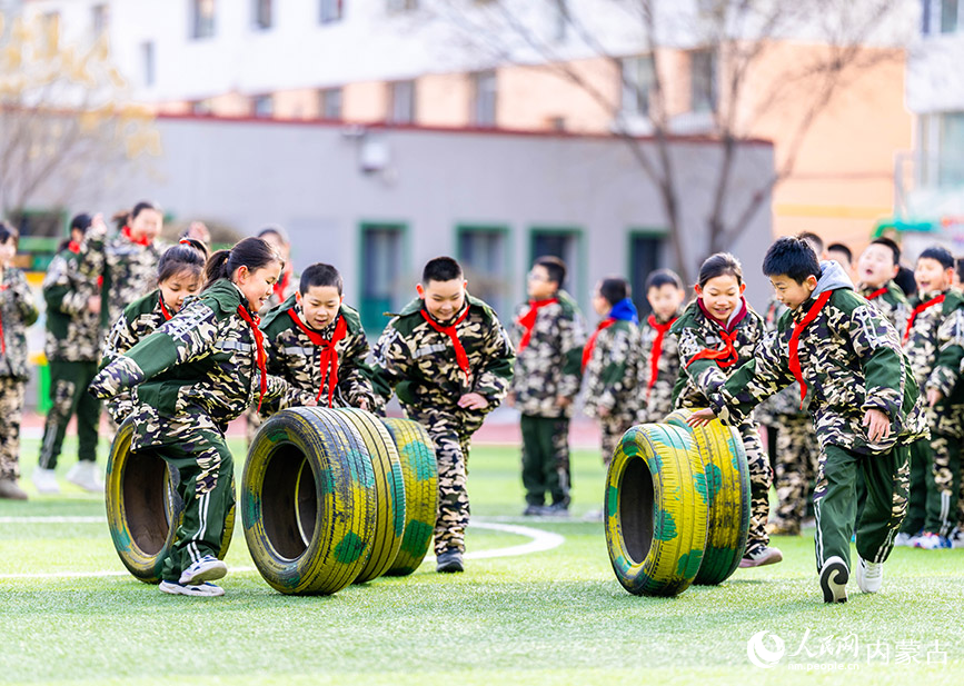 2月26日，呼和浩特市玉泉区五塔寺东街小学学生在进行滚轮胎趣味游戏。丁根厚摄