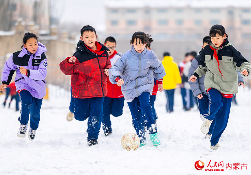 2月27日，孩子们在呼和浩特市玉泉区石东路小学校园雪地趣味足球赛比赛中。丁根厚摄