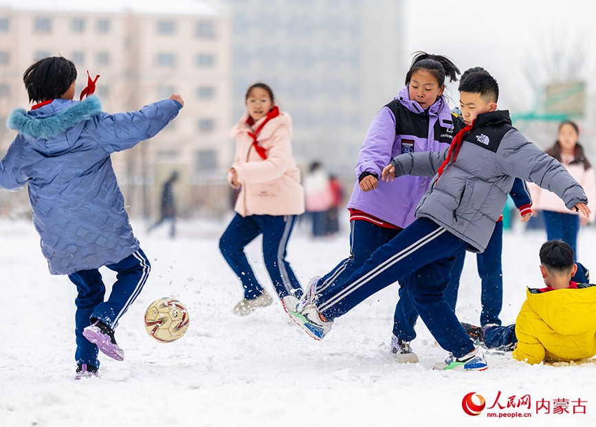 2月27日，孩子們在呼和浩特市玉泉區石東路小學校園雪地趣味足球賽比賽中拼搶。丁根厚攝