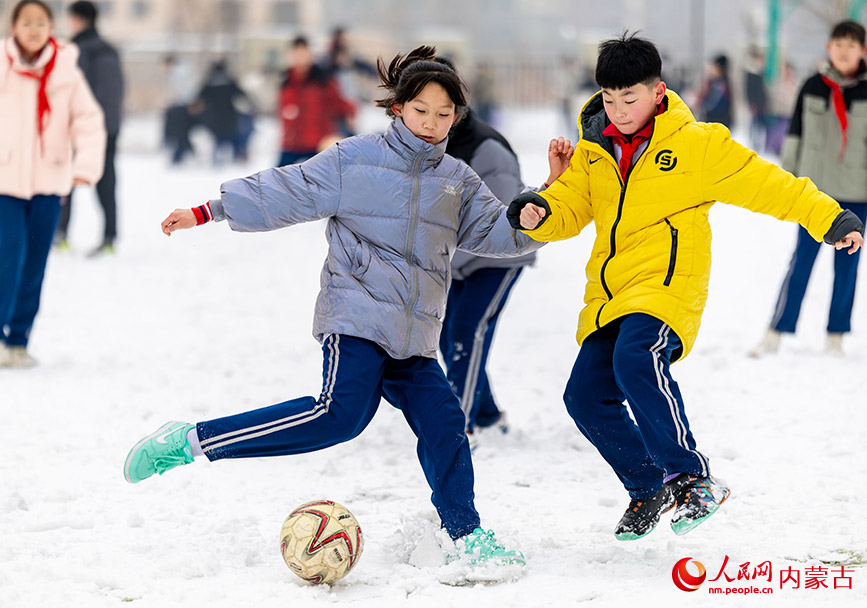 2月27日，孩子們在呼和浩特市玉泉區石東路小學校園雪地趣味足球賽比賽中射門。丁根厚攝