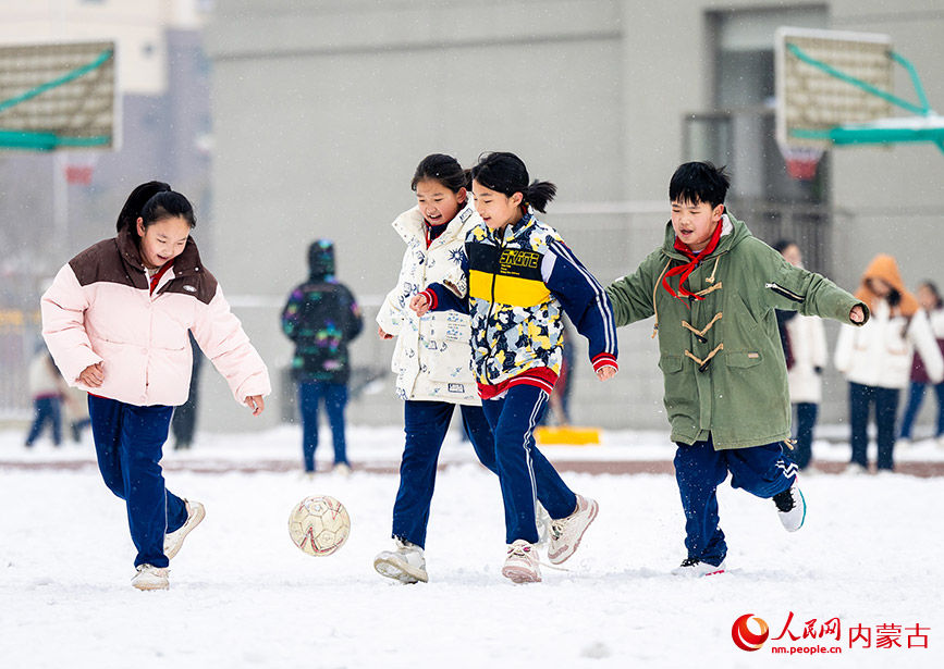 2月27日，孩子们在呼和浩特市玉泉区石东路小学校园雪地趣味足球赛比赛中。丁根厚摄