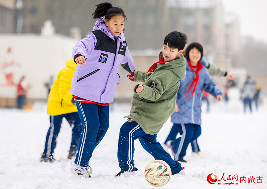 2月27日，孩子们在呼和浩特市玉泉区石东路小学校园雪地趣味足球赛比赛中拼抢。丁根厚摄
