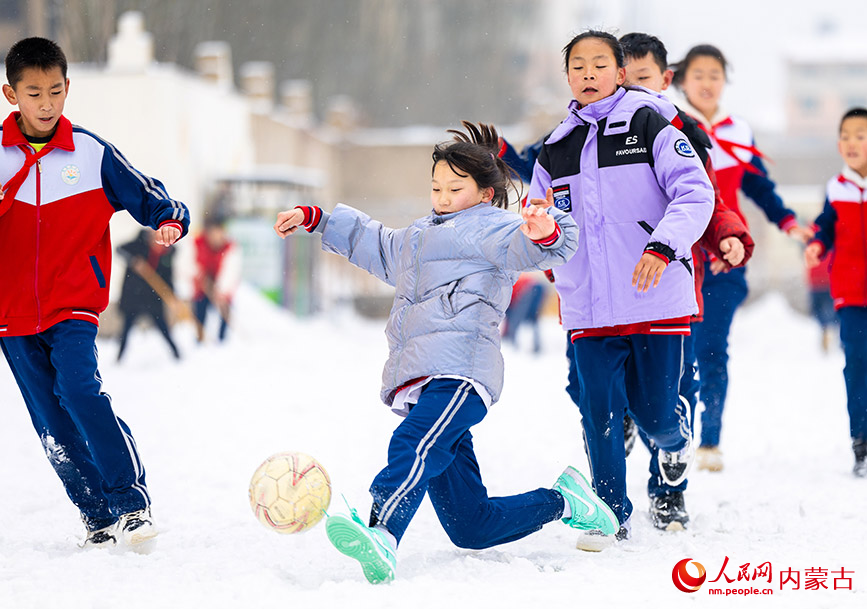 2月27日，孩子們在呼和浩特市玉泉區石東路小學校園雪地趣味足球賽比賽中拼搶。丁根厚攝