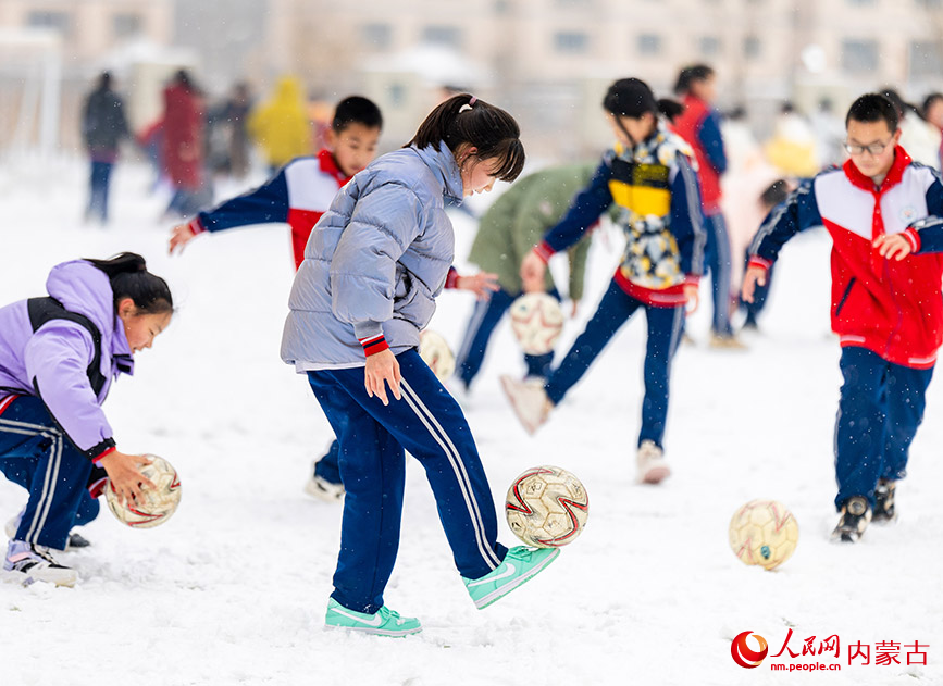 2月27日，孩子們在呼和浩特市玉泉區石東路小學校園雪地趣味足球賽比賽前練習顛球。丁根厚攝