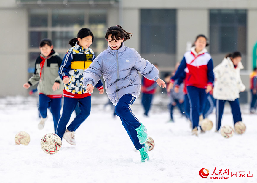 2月27日，孩子们在呼和浩特市玉泉区石东路小学校园雪地趣味足球赛比赛前热身。丁根厚摄