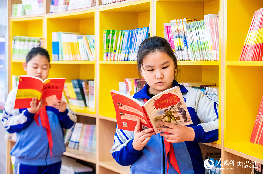 3月4日，呼和浩特市玉泉区通顺街小学学生在学校图书馆内阅读“雷锋的故事”图书。丁根厚摄