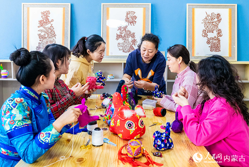 3月6日，非遗传承人董存娥（右三）在呼和浩特市玉泉区南柴火市街小学指导女教师学习制作布老虎。丁根厚摄