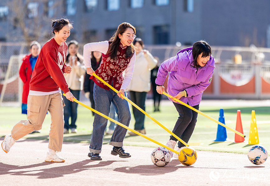 3月6日，呼和浩特市玉泉区南柴火市街小学女教师在参加趣味游戏。丁根厚摄
