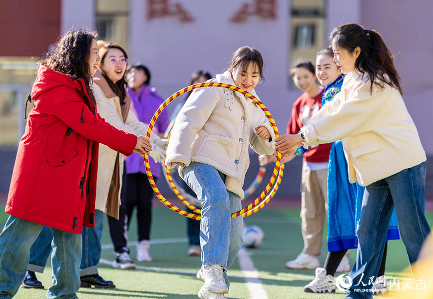 3月6日，呼和浩特市玉泉区南柴火市街小学女教师在参加“穿越障碍”趣味游戏。丁根厚摄
