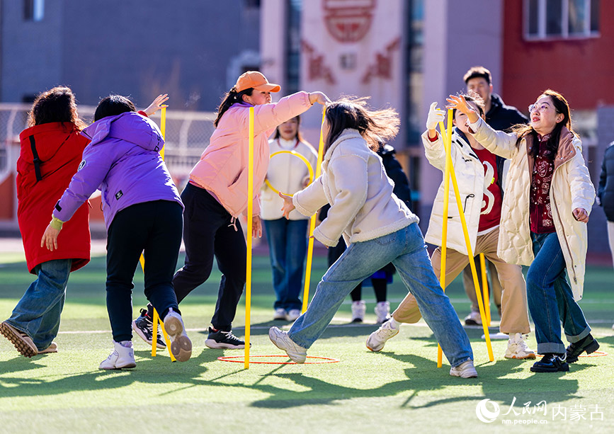 3月6日，呼和浩特市玉泉区南柴火市街小学女教师在参加“不倒森林”趣味游戏。丁根厚摄