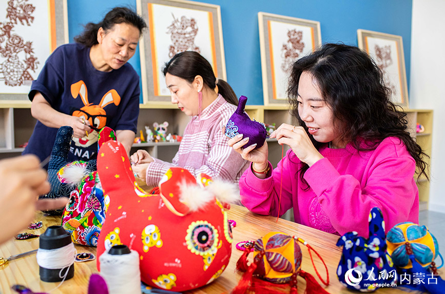 3月6日，呼和浩特市玉泉区南柴火市街小学女教师在学习制作布老虎。丁根厚摄