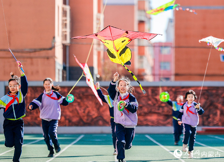 3月13日，呼和浩特市玉泉區恆昌店巷小學學生在操場上放飛風箏。丁根厚攝