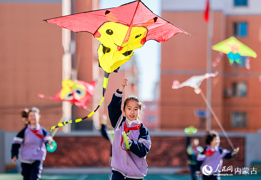 3月13日，呼和浩特市玉泉區恆昌店巷小學學生在操場上放飛風箏。丁根厚攝