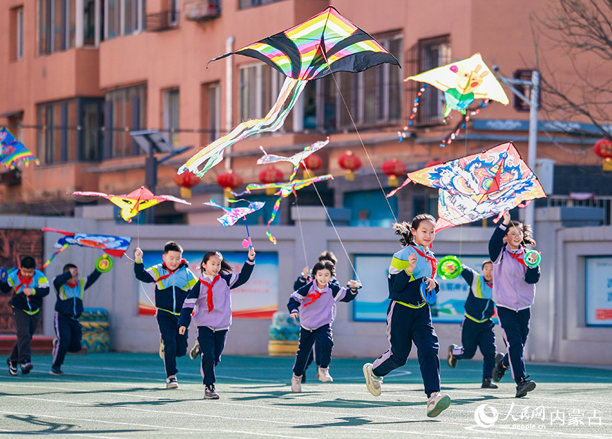 3月13日，呼和浩特市玉泉區恆昌店巷小學學生在操場上放飛風箏。丁根厚攝
