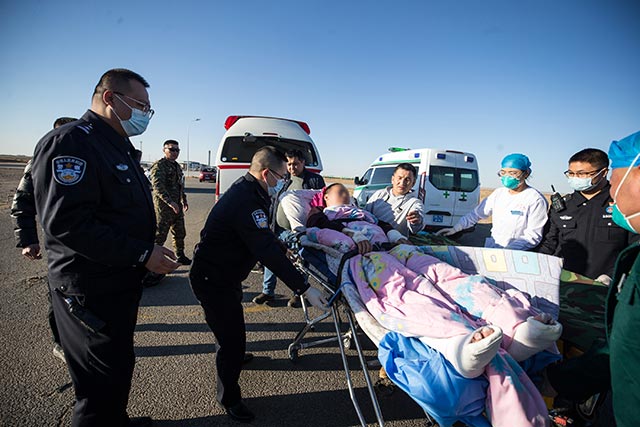 二连出入境边防检查站移民管理警察协助救护人员将伤者转移至中方救护车。