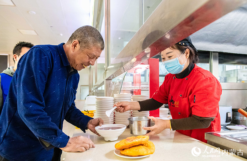3月18日，求职者在呼和浩特市玉泉区零工市场劳动用工综合服务中心餐厅取餐。丁根厚摄