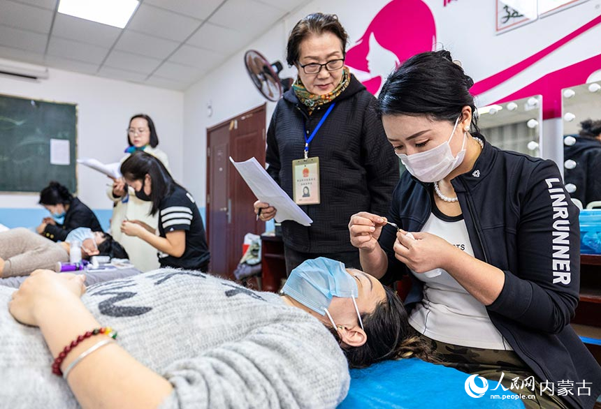 学员们在呼和浩特市玉泉区举办的美容师培训班上参加理论考试和技能考核。丁根厚摄