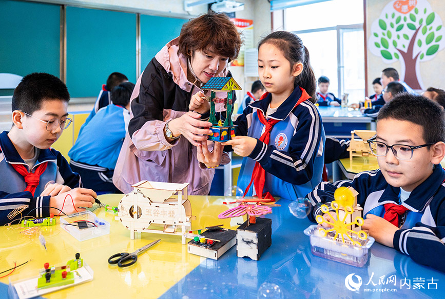 3月27日，呼和浩特市玉泉区清泉街小学老师在指导学生制作科创小作品。丁根厚摄