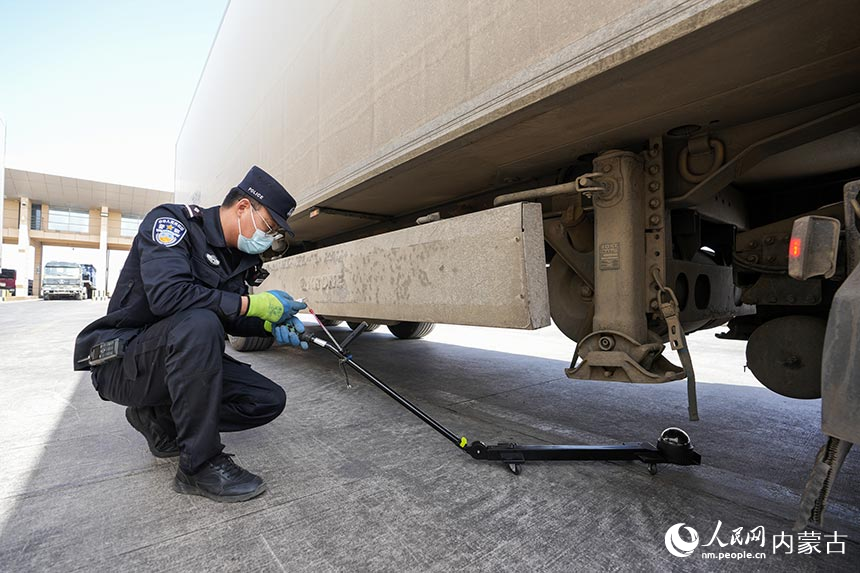 二连出入境边防检查站移民管理警察对通关货车进行车体检查。郭鹏杰摄